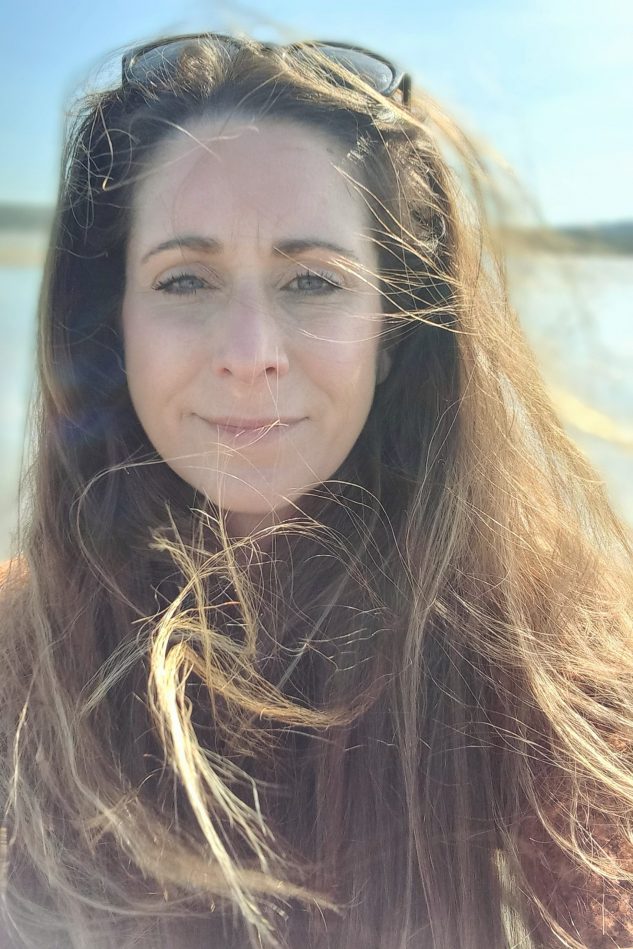 A warm and approachable woman smiling confidently, creating a safe and welcoming space for transformation and healing.